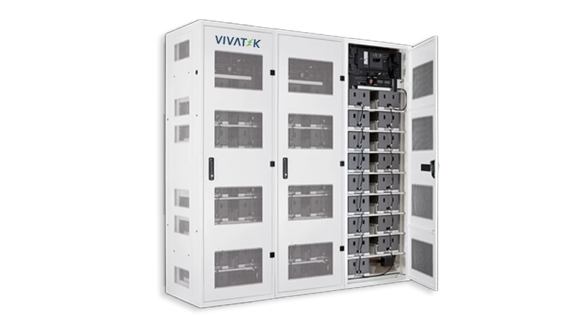 Technician checking a rack of lithium ion batteries connected to an industrial UPS system in a factory electrical room