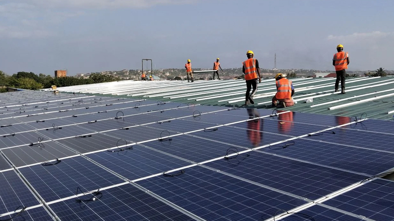 solar EPC contractors India installing rooftop solar panels on an industrial building with safety harness and quality inspection